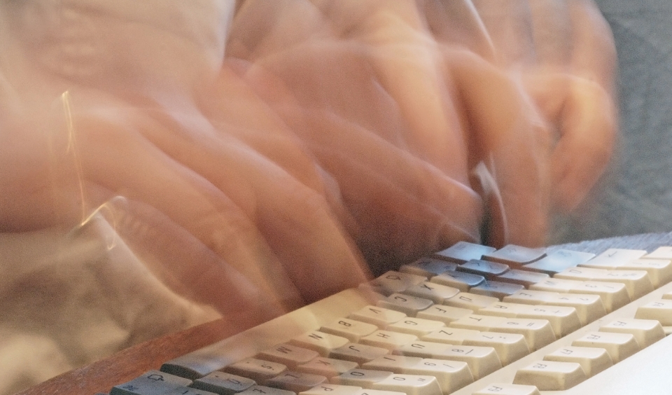 Händer som skriver snabbt på tangentbord